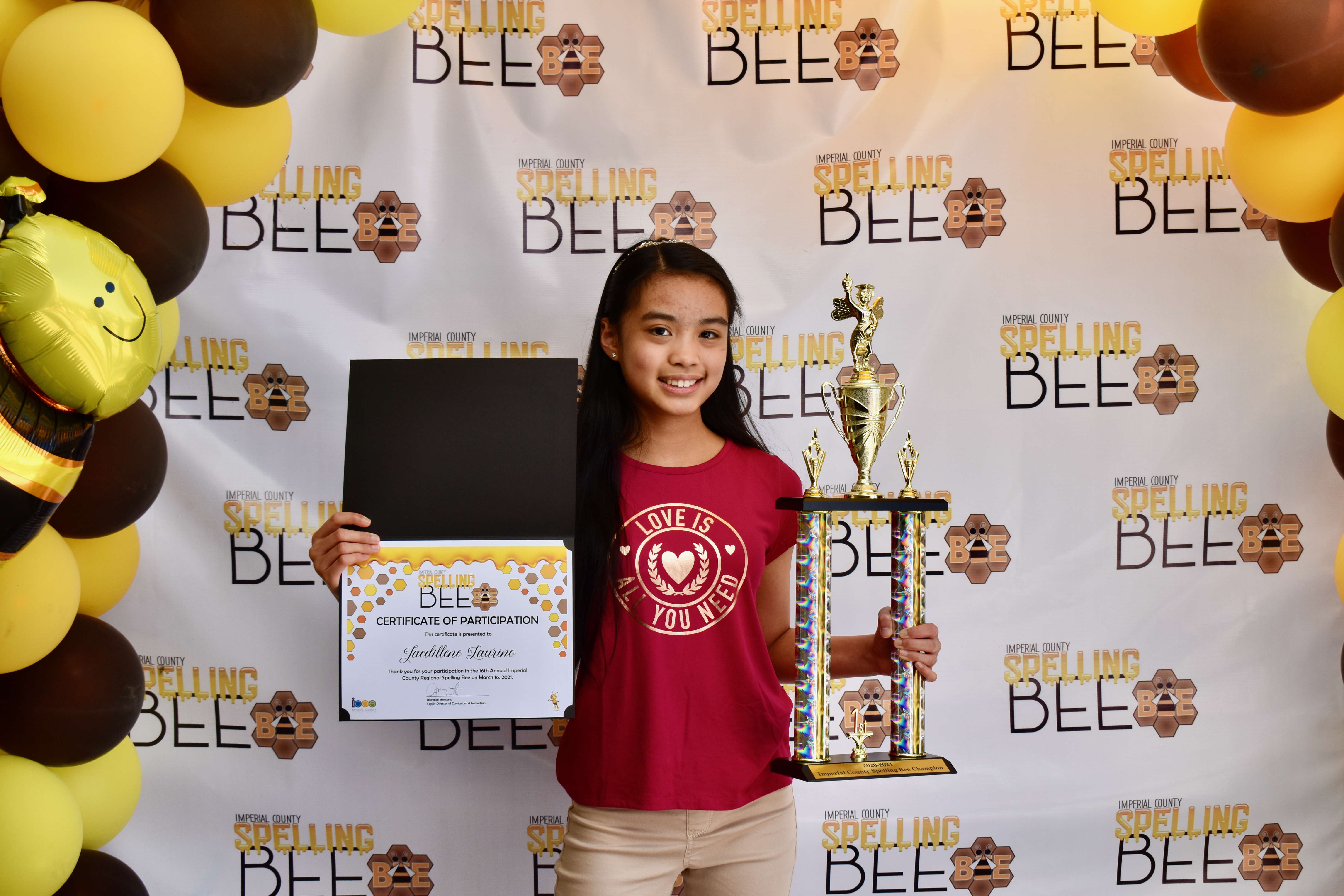 student holding trophy and certificate